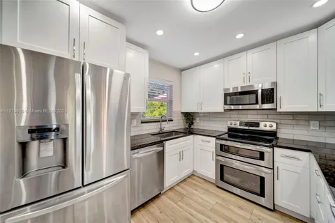 a kitchen with stainless steel appliances and refrigerator
