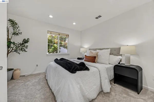 a bedroom with bed and a potted plant