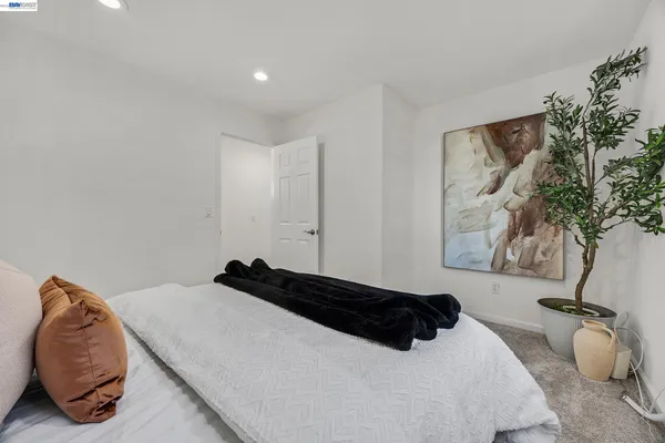 a bedroom with a bed and a potted plant