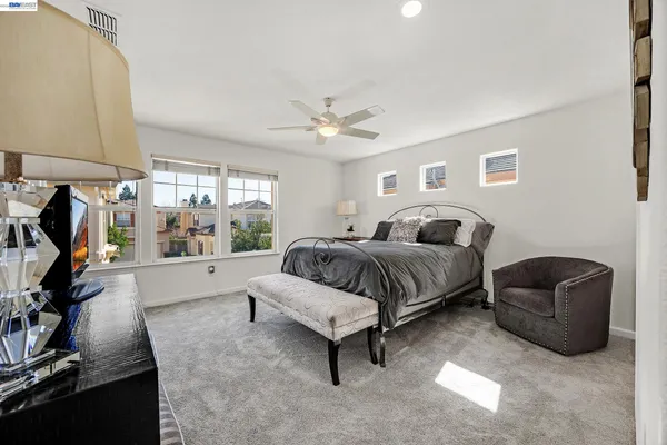 a spacious bedroom with a bed a couch and a window