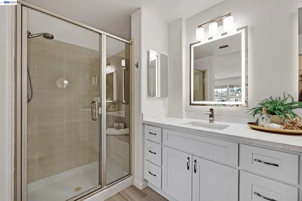 a bathroom with a shower sink and mirror
