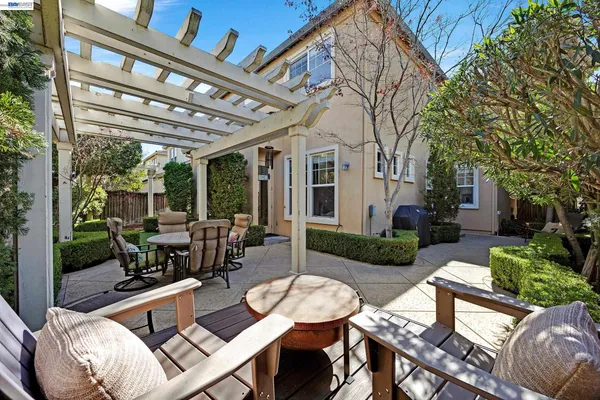 a view of a patio with couches table and chairs with wooden floor and fence