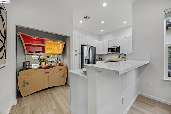 a view of a kitchen with furniture and wooden floor