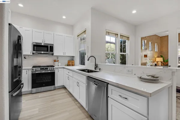 a kitchen with sink stove and refrigerator