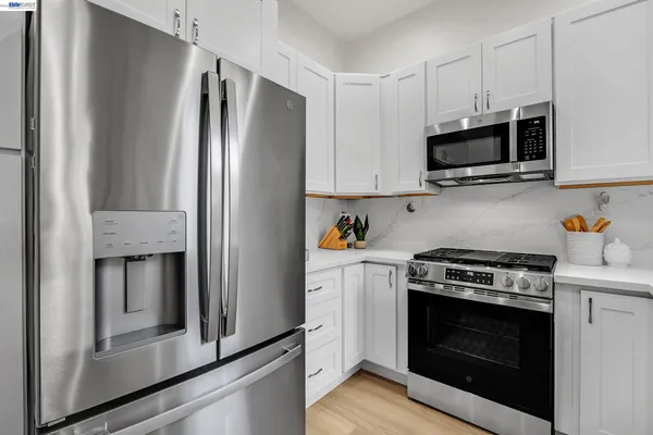 a kitchen with stainless steel appliances white cabinets a stove and a refrigerator