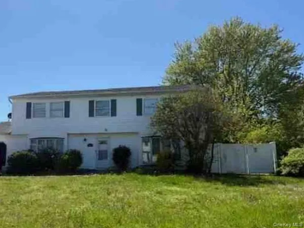 a view of a house with a yard and a tree
