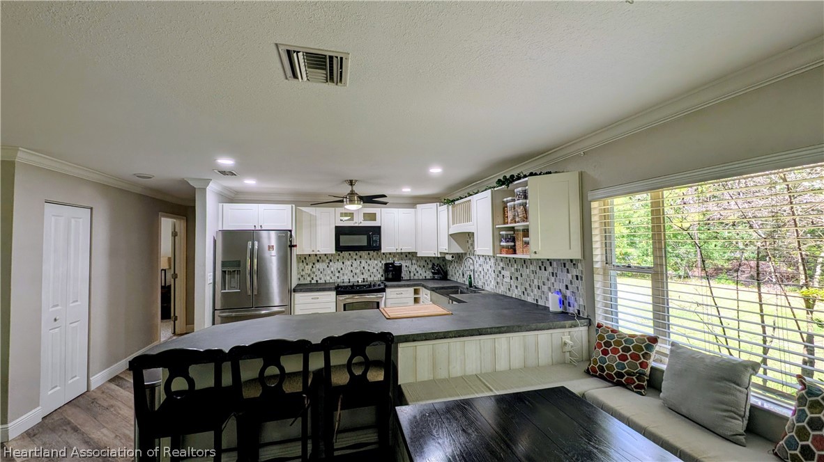 6218 Apple Road Sebring, FL 33875 - Photo 12 of 40 a view of a dining room with furniture window and wooden floor