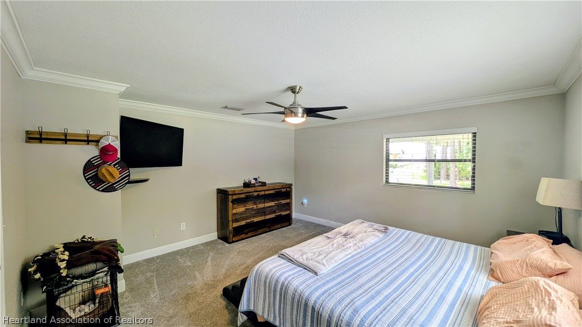 6218 Apple Road Sebring, FL 33875 - Photo 14 of 40 a bedroom with a bed and a flat tv screen on a dresser