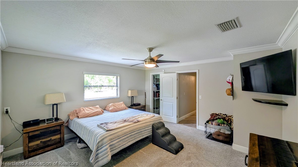 6218 Apple Road Sebring, FL 33875 - Photo 15 of 40 a bedroom with a bed and a flat tv screen on a dresser