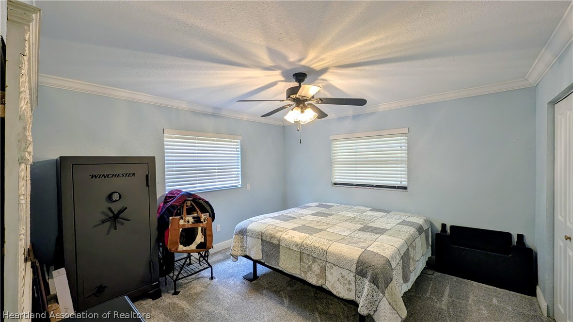 6218 Apple Road Sebring, FL 33875 - Photo 22 of 40 a bedroom with a bed and a chandelier