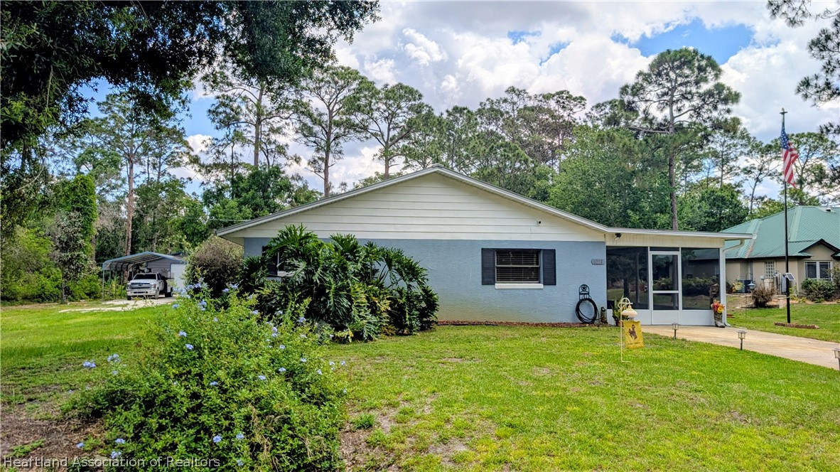6218 Apple Road Sebring, FL 33875 - Photo 32 of 40 a view of backyard of house with wooden deck and seating space