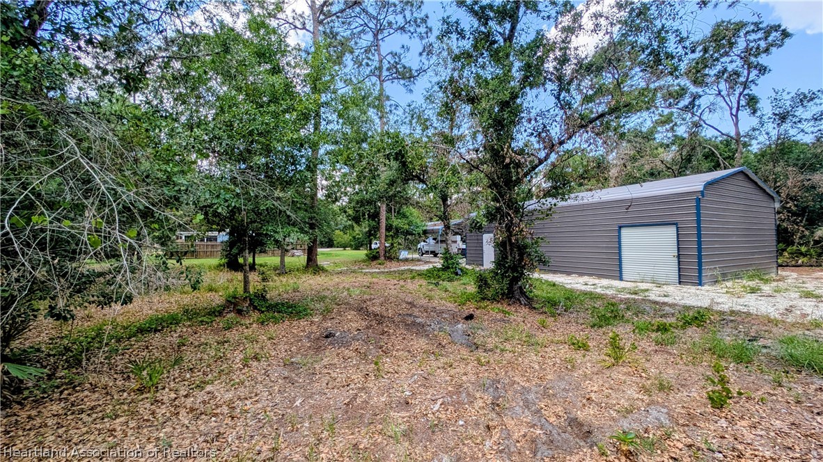 6218 Apple Road Sebring, FL 33875 - Photo 7 of 40 a backyard of a house with lots of plants and large trees