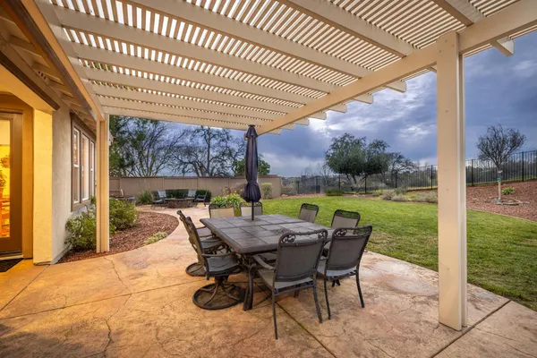 a view of a patio with table and chairs next to a yard
