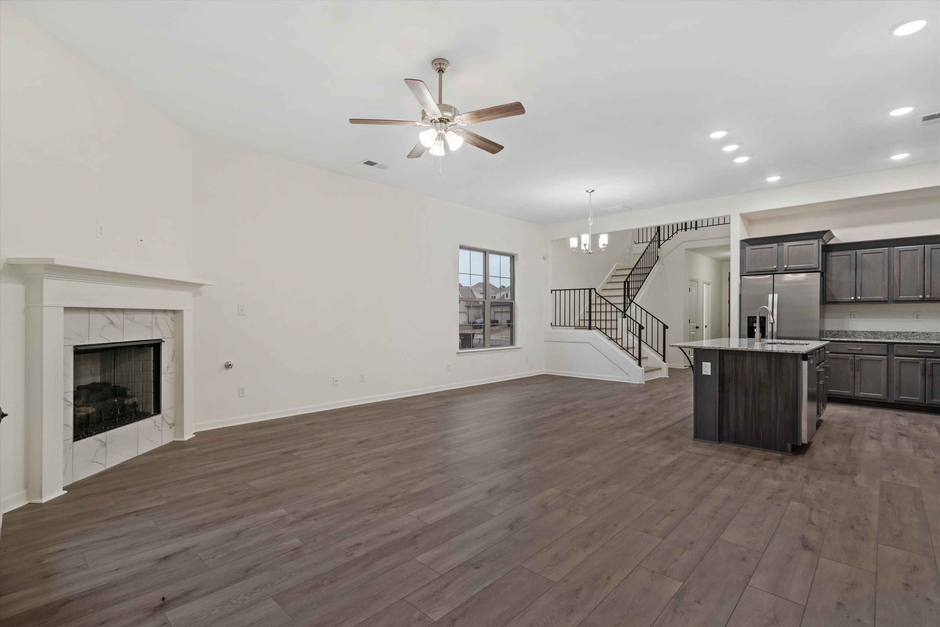 300 Maple Street Oakland, TN 38060 - Photo 11 of 27 a view of a room with wooden floor a ceiling fan and windows