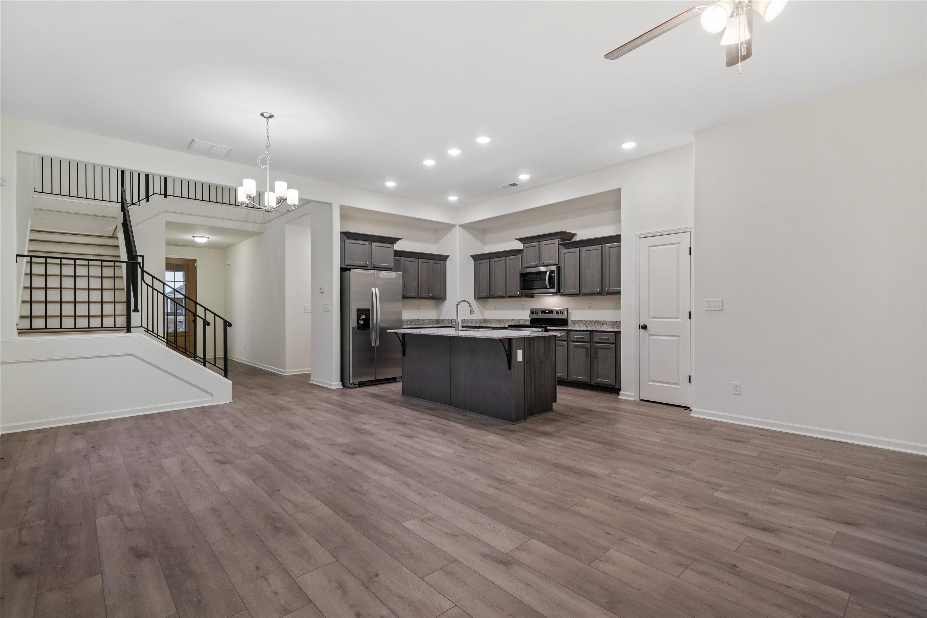 300 Maple Street Oakland, TN 38060 - Photo 12 of 27 a large kitchen with a lot of cabinets a counter top space stainless steel appliances and a ceiling fan