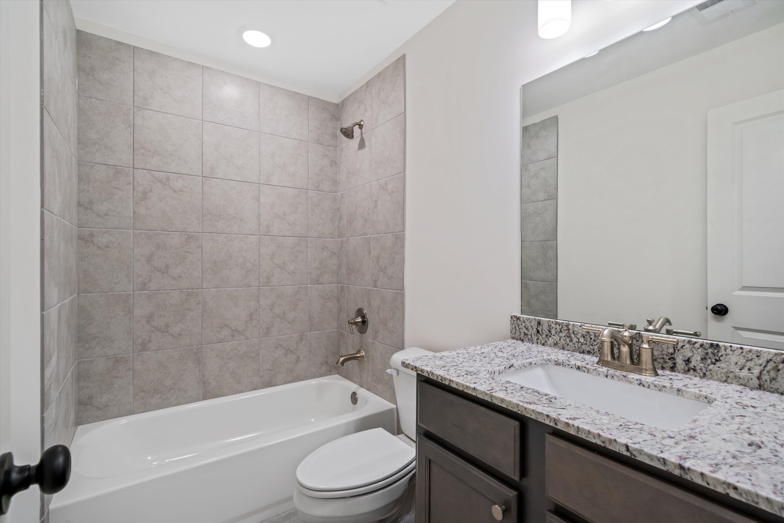 300 Maple Street Oakland, TN 38060 - Photo 24 of 27 a bathroom with a granite countertop sink a toilet and bathtub