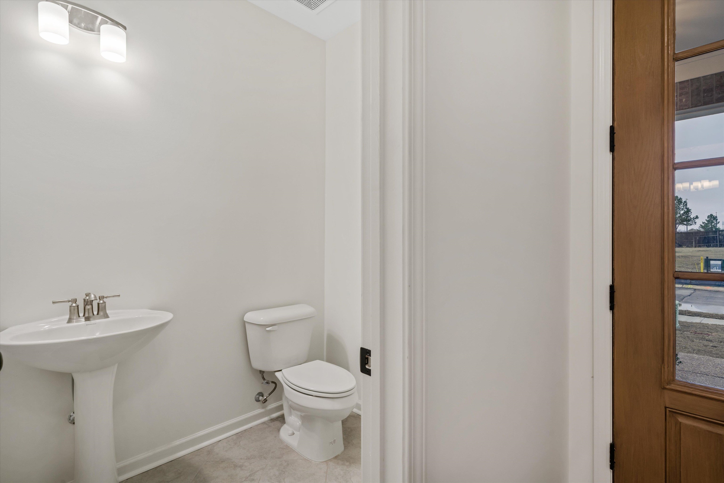 300 Maple Street Oakland, TN 38060 - Photo 5 of 27 a bathroom with a toilet a sink and a window