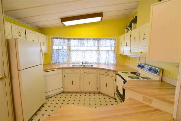 a kitchen with a refrigerator a sink and a window