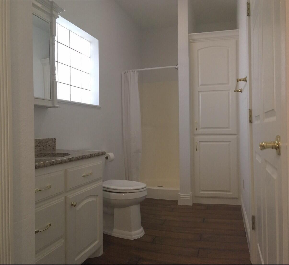 101 Southeast 6th Plainview, TX 79072 - Photo 22 of 31 a bathroom with a granite countertop sink toilet and window