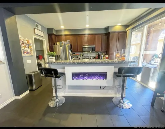 a kitchen with stainless steel appliances kitchen island granite countertop a refrigerator and stove