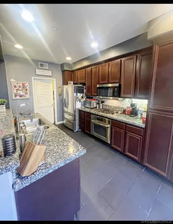 a kitchen with stainless steel appliances granite countertop a stove a sink dishwasher and a refrigerator