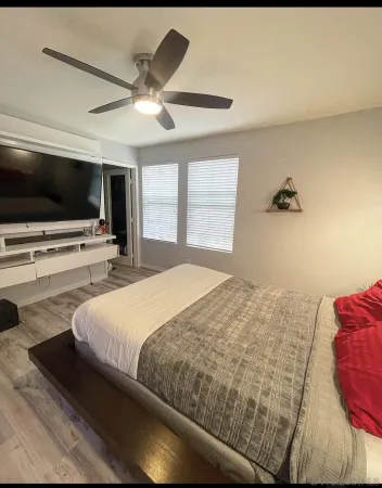a bedroom with a bed and a flat screen tv