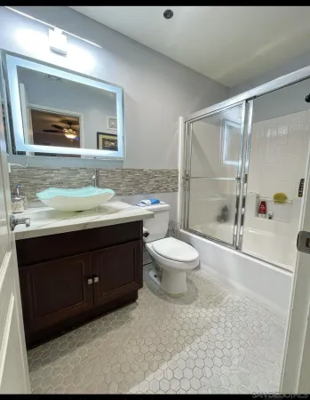 a bathroom with a sink vanity mirror and toilet