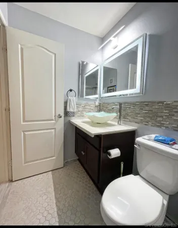a bathroom with a toilet sink and mirror
