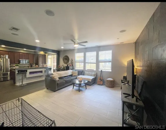 a living room with furniture a large window and stainless steel appliances