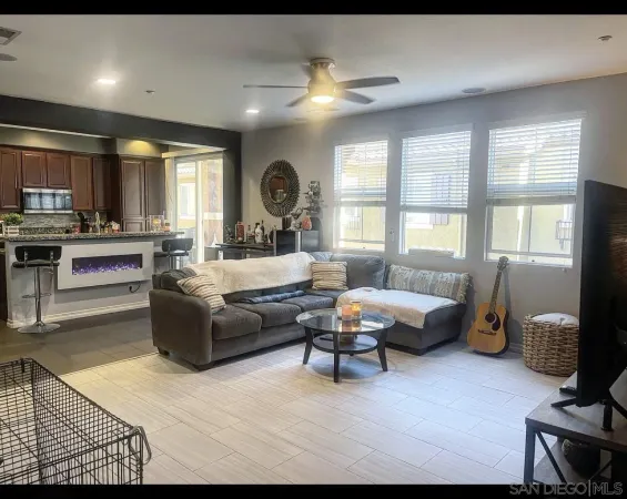 a living room with furniture a large window and a fireplace