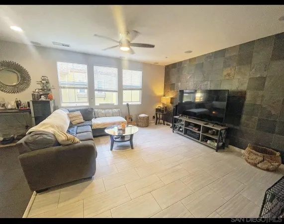 a living room with furniture a flat screen tv and a window