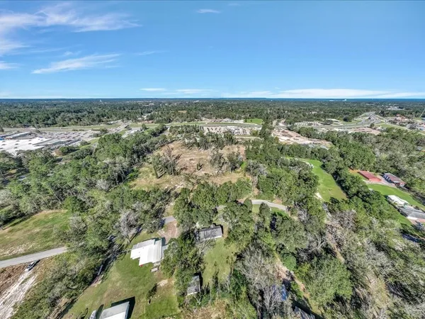 an aerial view of residential houses with outdoor space and trees