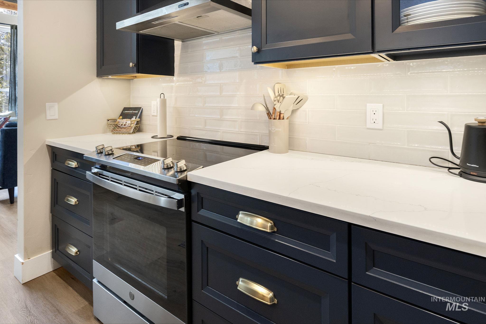 127 Jacks Loop Donnelly, ID 83615 - Photo 16 of 46 Kitchen with stainless steel range with electric stovetop, light stone countertops, tasteful backsplash, and light wood-style flooring