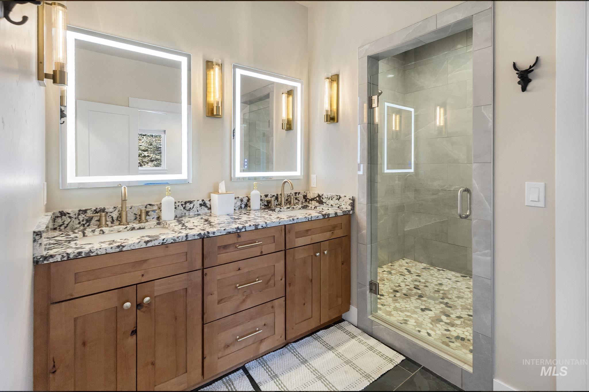 127 Jacks Loop Donnelly, ID 83615 - Photo 21 of 46 Full bathroom featuring a shower stall, double vanity, and tile patterned flooring