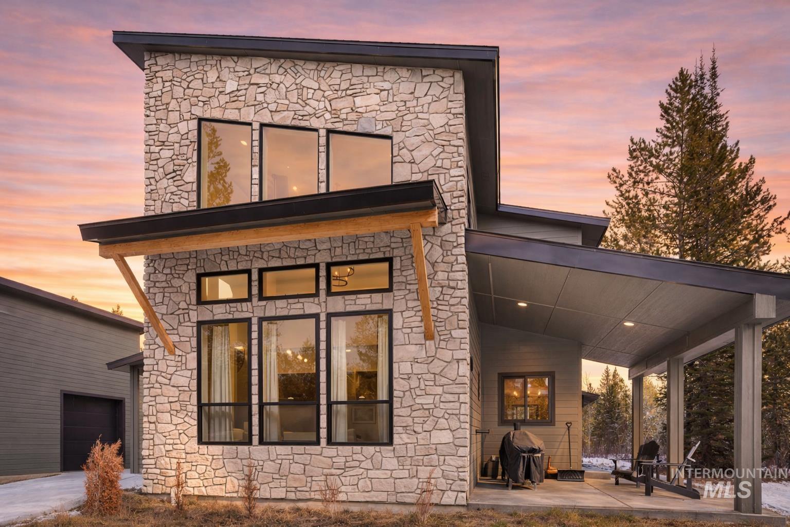 127 Jacks Loop Donnelly, ID 83615 - Photo 3 of 46 Back of house with stone siding and a patio