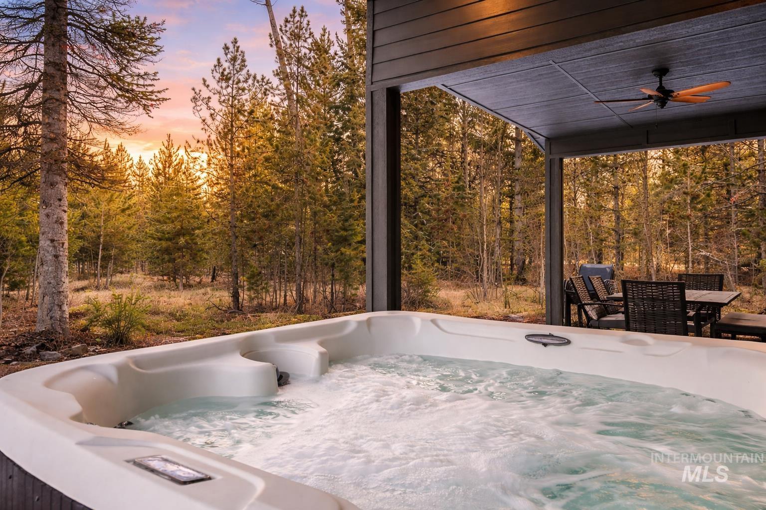 127 Jacks Loop Donnelly, ID 83615 - Photo 36 of 46 Patio terrace at dusk with ceiling fan, outdoor dining space, and a hot tub