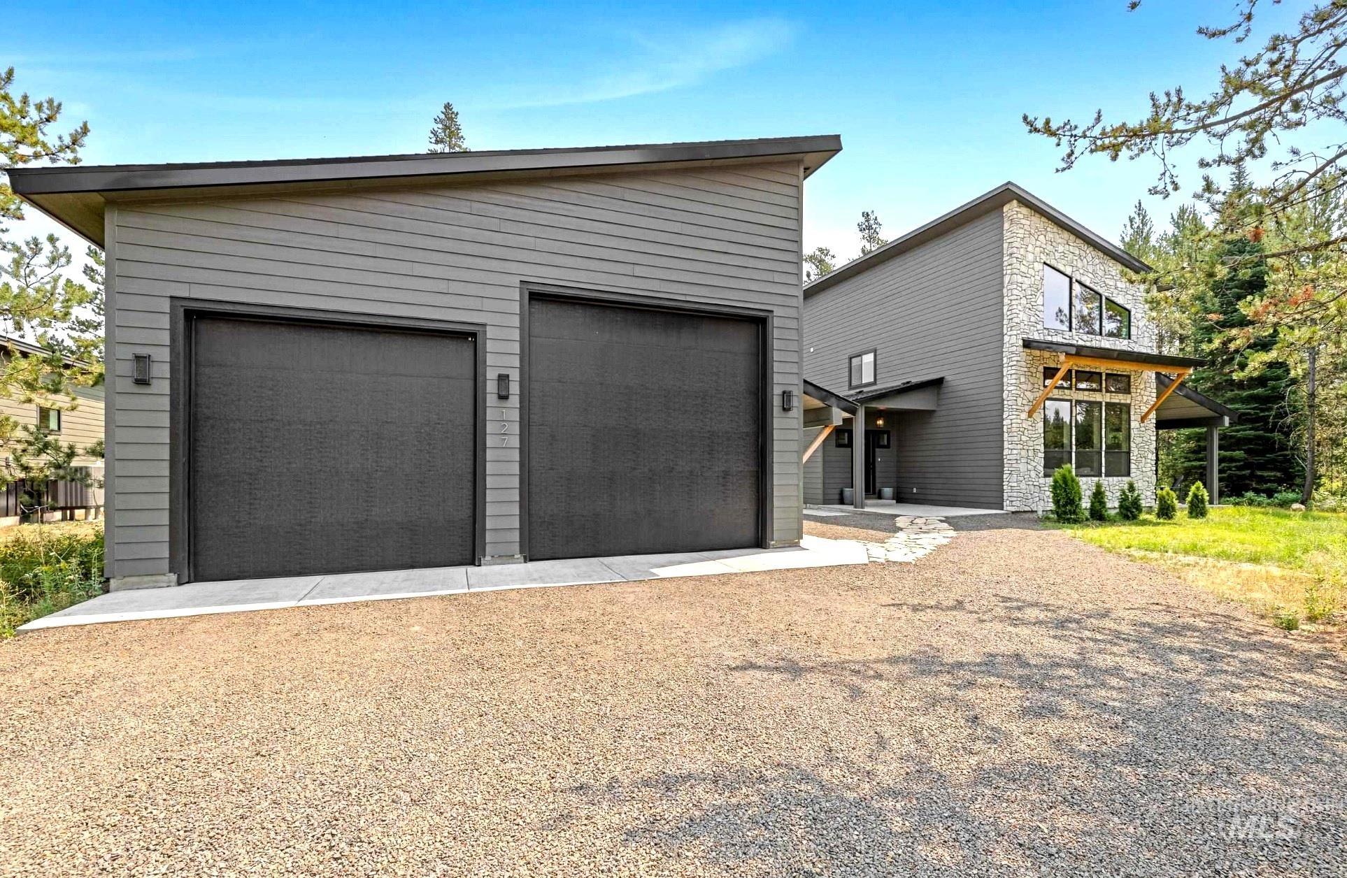 127 Jacks Loop Donnelly, ID 83615 - Photo 45 of 46 View of front facade featuring stone siding, an outbuilding, and a garage