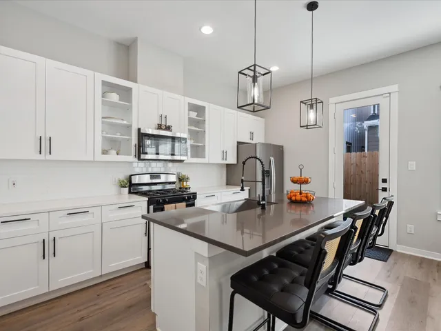 a kitchen with a sink a stove and chairs