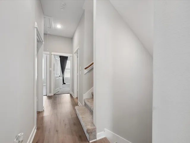 a view of a hallway with wooden floor