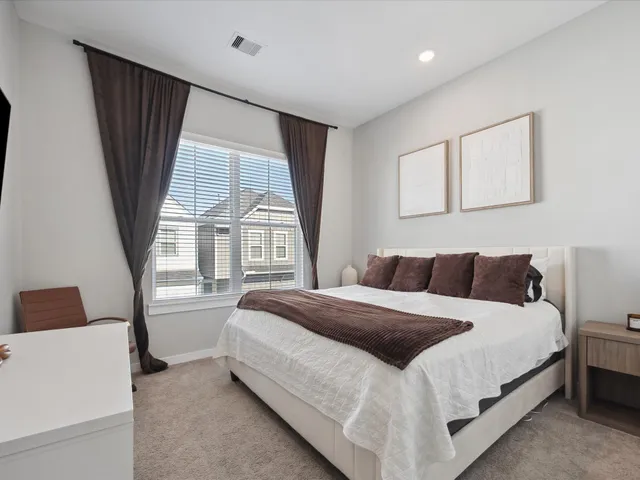 a bedroom with a bed and a large window