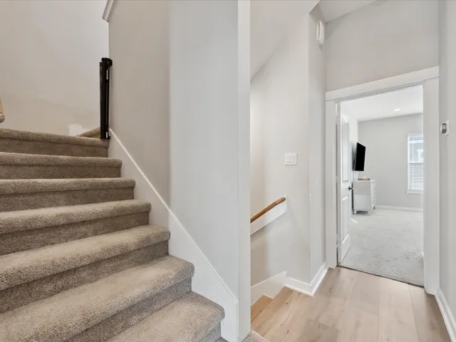 a view of staircase with white walls and railing