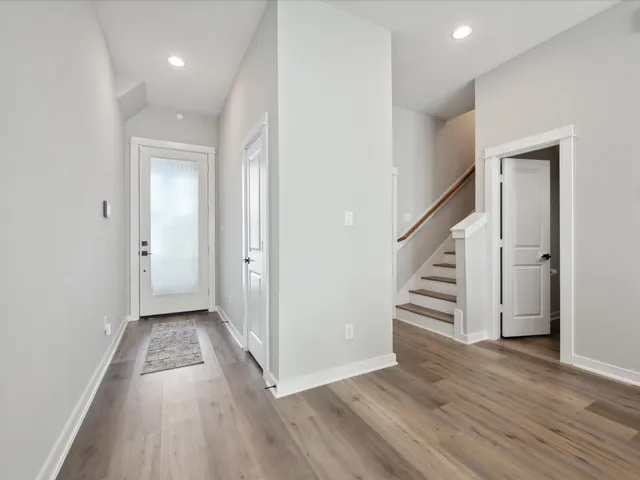 a view of a hallway with wooden floor and entryway