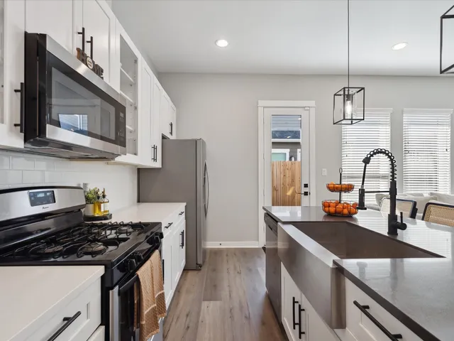 a kitchen with stainless steel appliances granite countertop a sink stove and refrigerator