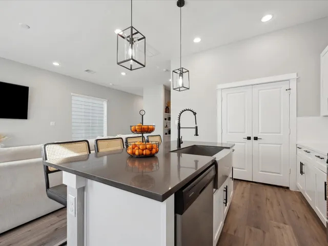 a kitchen with stainless steel appliances granite countertop a sink a stove and a refrigerator