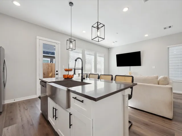 a kitchen with stainless steel appliances granite countertop a sink a microwave and a dining table with wooden floor