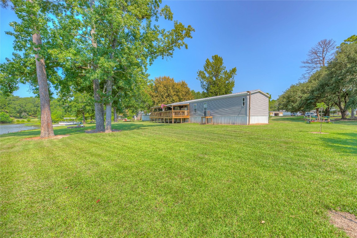 a view of a house with a big yard and large trees