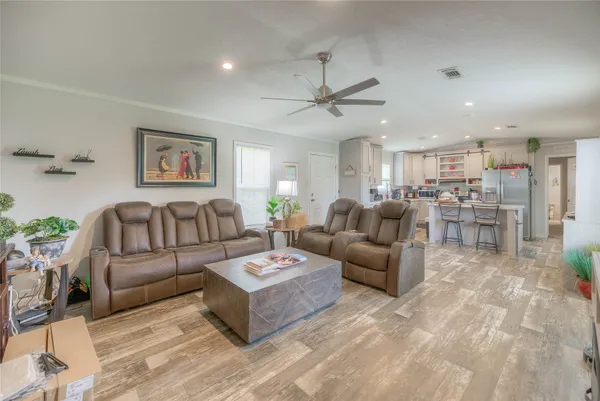 a living room with furniture kitchen view and a chandelier