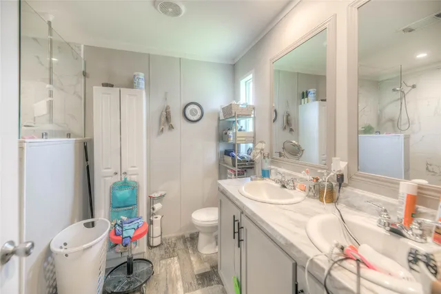 a bathroom with a sink a toilet and shower