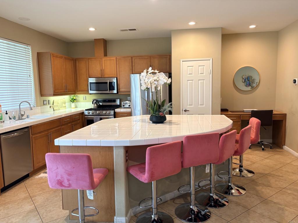 80596 Key Largo Avenue Indio, CA 92201 - Photo 11 of 59 a kitchen with a dining table chairs and refrigerator
