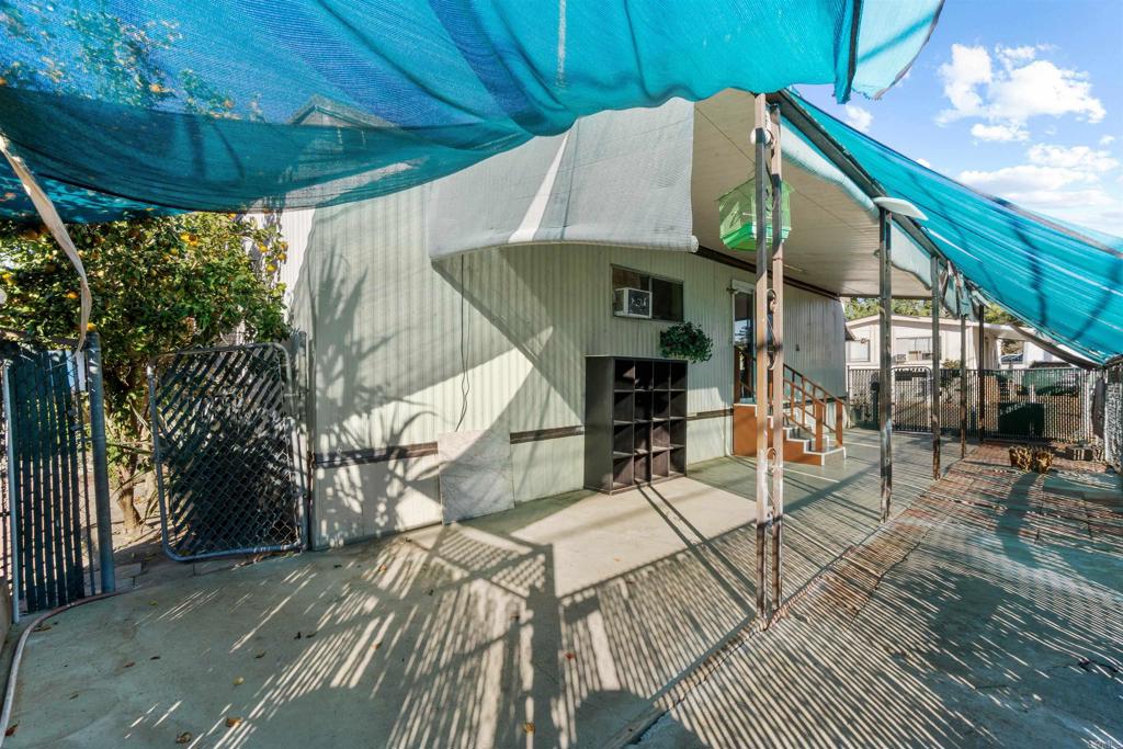 12044 Royal Road, Unit 93 El Cajon, CA 92021 - Photo 27 of 29 a roof deck with table and chairs under an umbrella